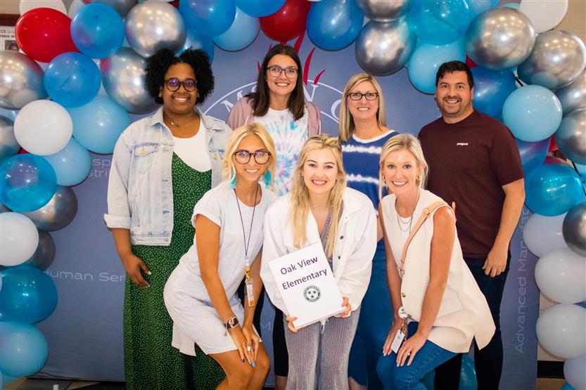 A group of teachers smile